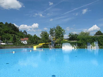 Schwimmbecken mit Rutsche im Hintergrund
