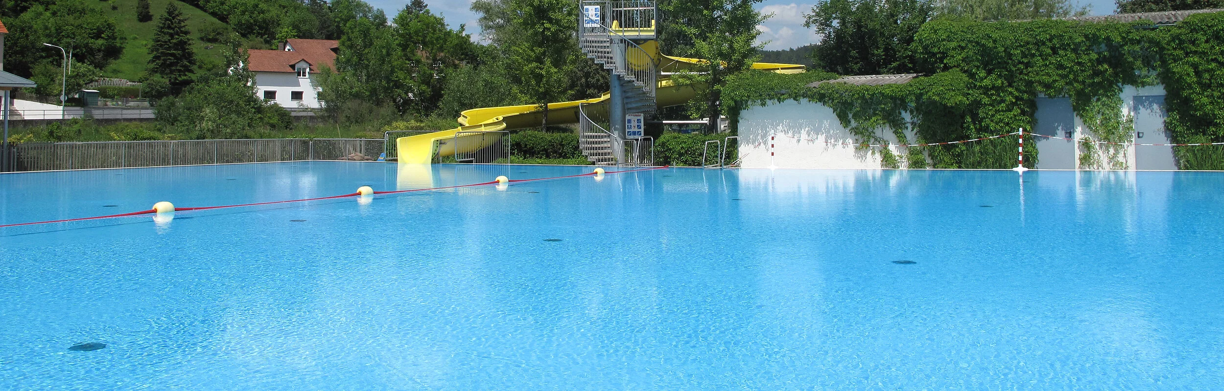 Schwimmbecken mit Rutsche im Hintergrund