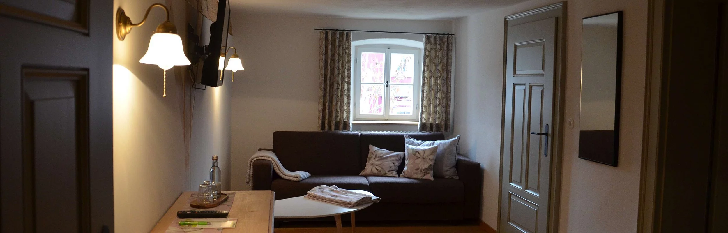 Wohnzimmer in der Gasthof Krone Kinding mit einem gemütlichen Sofa mit Beistelltisch und einem Fernsehen.