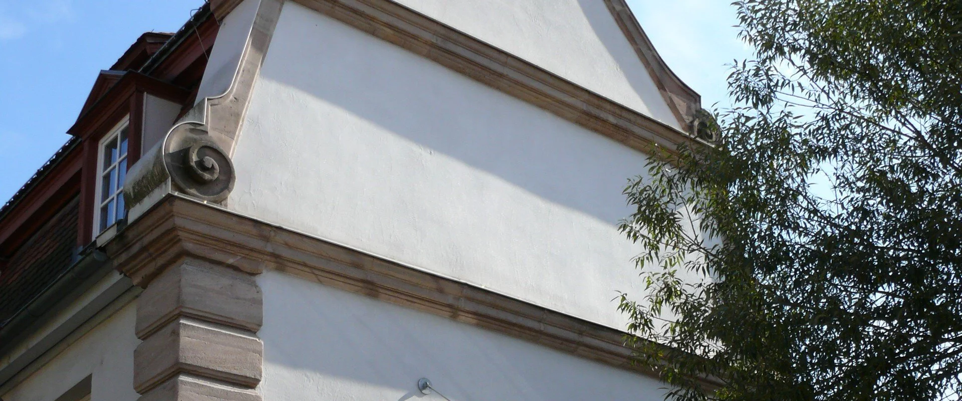 Außenfrontansicht des Jugenhauses in Roth. Ein schön restauriertes weißes Gebäude. Zur Eingangstür führt eine kleine Treppe hinauf.