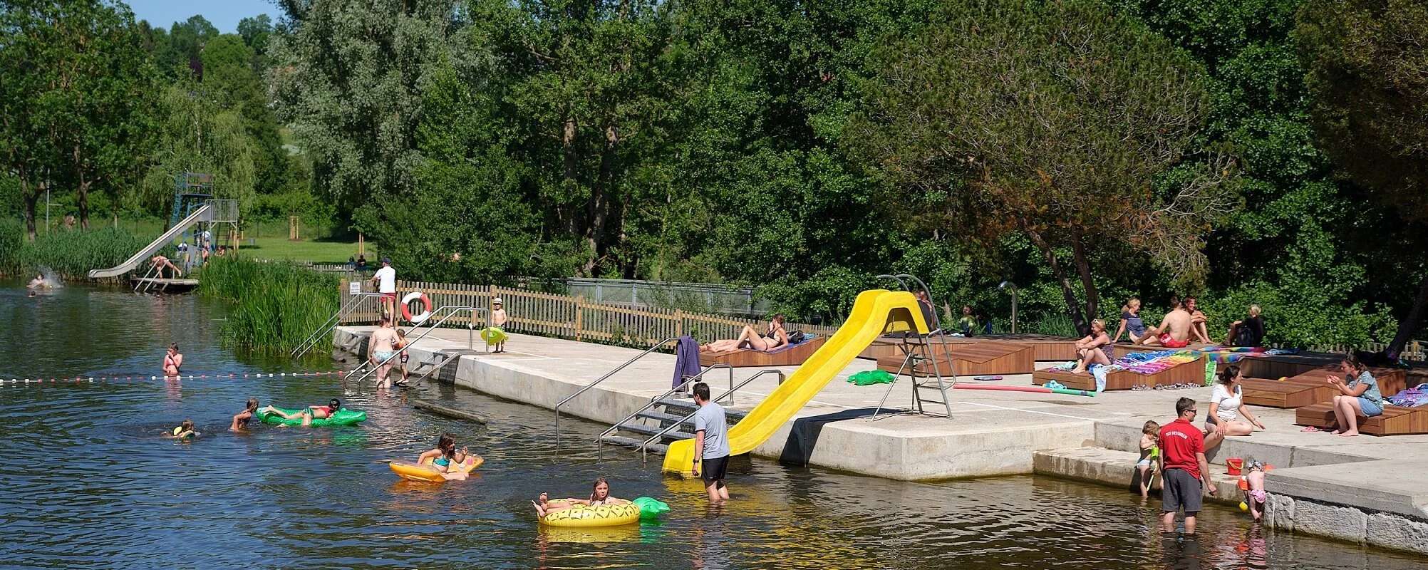 Badende im Wörnitz-Flussfreibad in Oettingen. Auf dem Bild ist auch die Rutsche für die Kinder zu sehen.