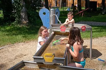 Drei Kinder am Wasserspiel im Wörnitzfreibad