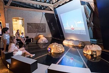 Besucher sehen sich einen Film über den Meteoriteneinschlag an