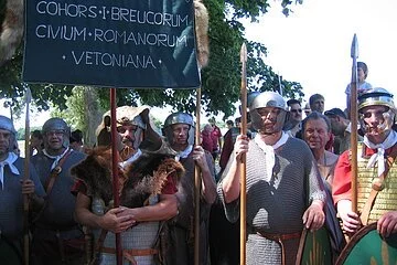 Eine große Gruppe Männer ist verkleidet als römische Legionäre. Die Männer tragen Helme, Lanzen, Kettenhemden oder Brustpanzer.
