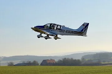 Ein kleines Flugzeug ist gerade von der Landebahn in die Luft gestartet.