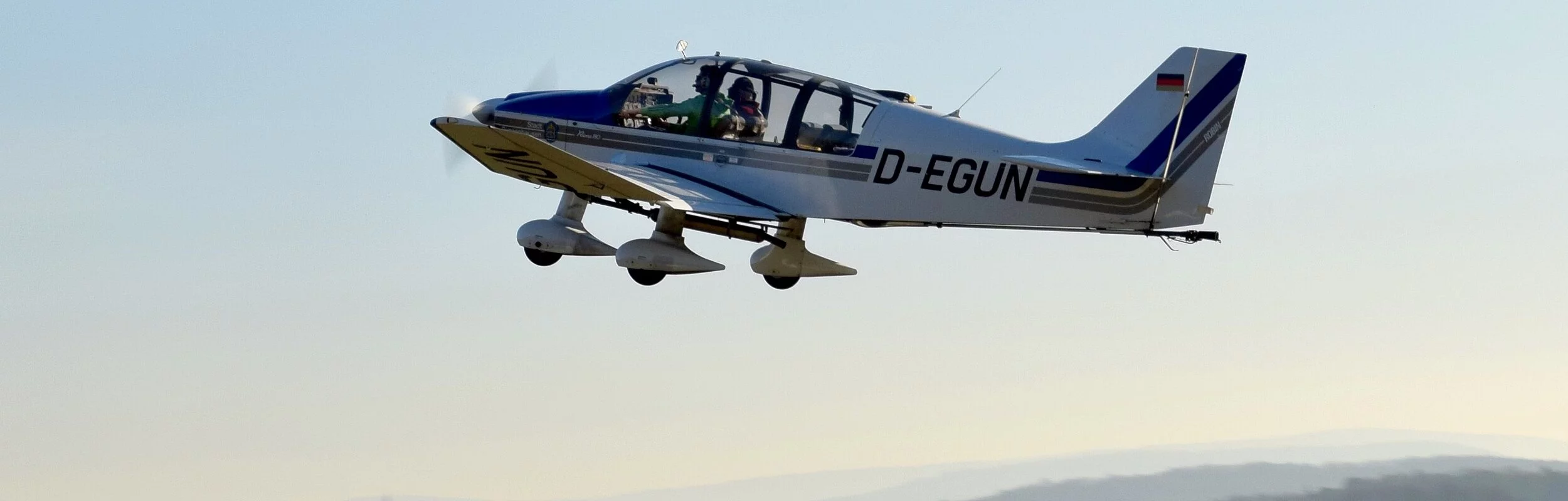 Ein kleines Flugzeug ist gerade von der Landebahn in die Luft gestartet.