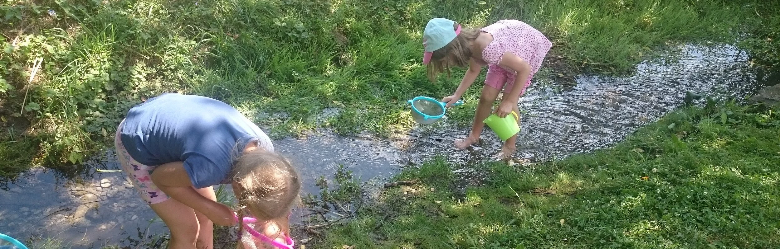 Kinder keschern am Bach