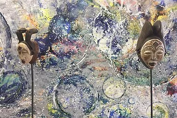 2 Masken vor einer bemalten Wand