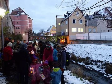 Luzien-Häuschen-Schwimmen mit Führung Gruppe von Eltern und Kindern mit Lichterhäuschen (kleinen Papierhäuschen mit Kerze) im Dezember