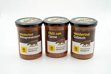 Es sind drei Gläser mit den verschiedenen Produkten des Weiderinds abgebildet. Einmal Bolonesesauce, Chili con Carne und Gulasch.