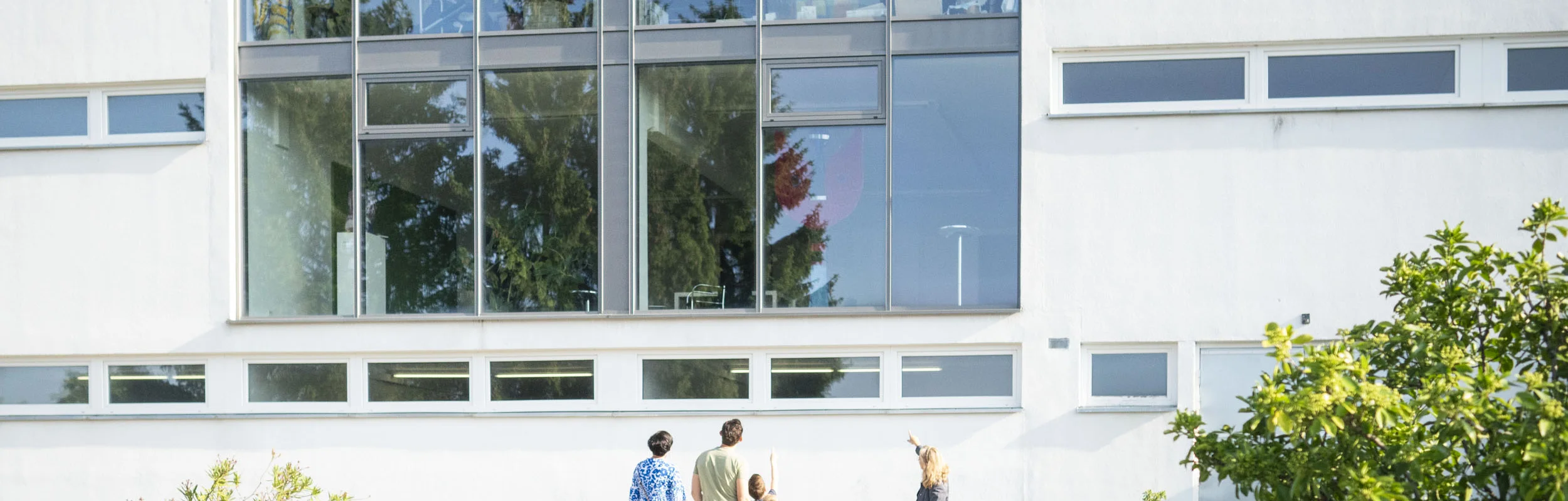 Die Leiterin des KunstMuseums zeigt das Museum von außen und führt es einer Gruppe vor.
