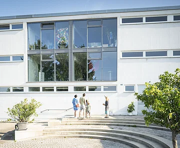 KunstMuseum Donau-Ries Die Leiterin des KunstMuseums zeigt das Museum von außen und führt es einer Gruppe vor.
