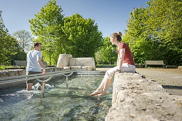 Wassertreten im Kurpark Pärchen beim Wassertreten im Kurpark. Frau schaut zu und Mann tritt Wasser.