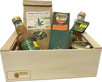 Altmühltaler Schmankerl Kistchen Holzkiste mit verschiedenen regionalen Produkten: Apfelsaft, Hanftee, Kürbiskerne, Wacholderlikör und Honig.