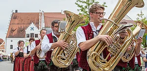 Blasmusikgruppe in Trachten spielt Blechblasinstrumente bei einem Umzug in einer deutschen Stadt.