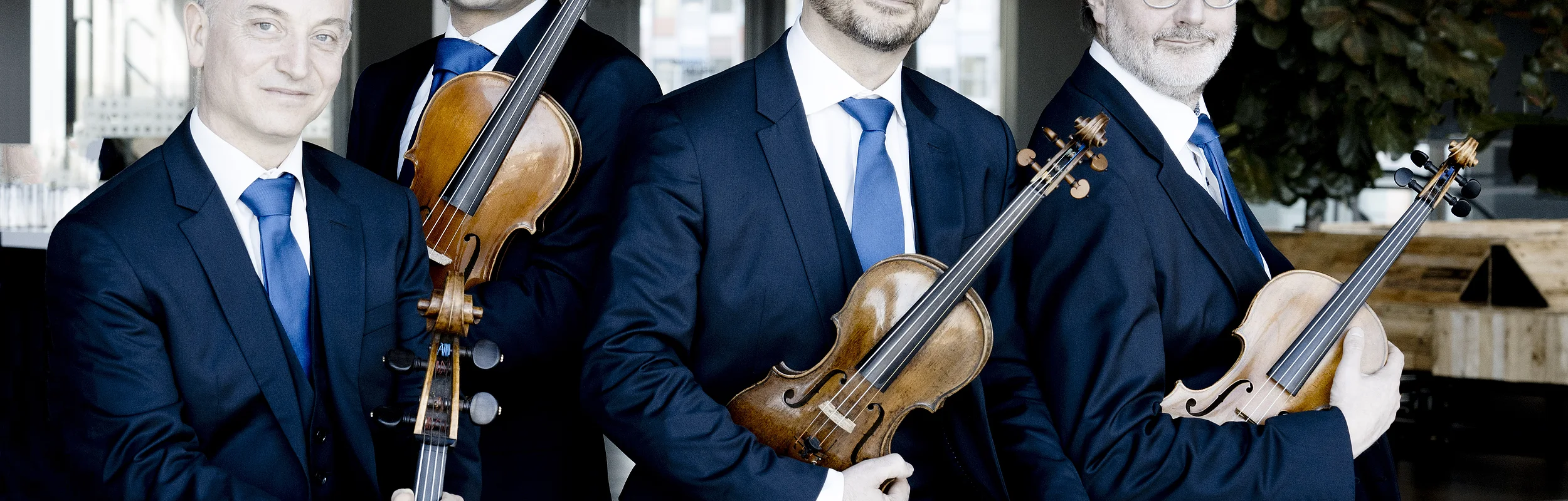 Die vier Musiker des Streichquartetts Quatuor Danel mit ihren Instrumenten sitzend.