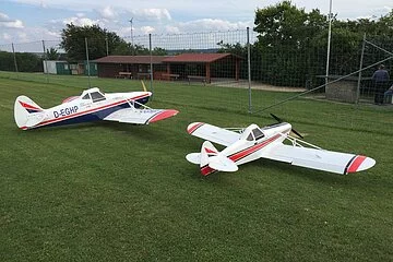 Zwei Modellflieger am Sportplatz.